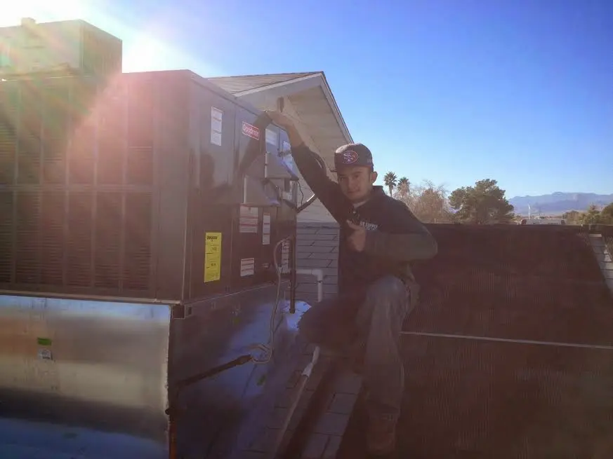 HVAC technician performing Air Duct Repair on a rooftop unit in Goldenrod